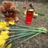 Blumen, eine Kerze und Teddys liegen auf dem Waldboden nahe der Kriegsgräberstätte. Die Anteilnahme der Bevölkerung ist groß.