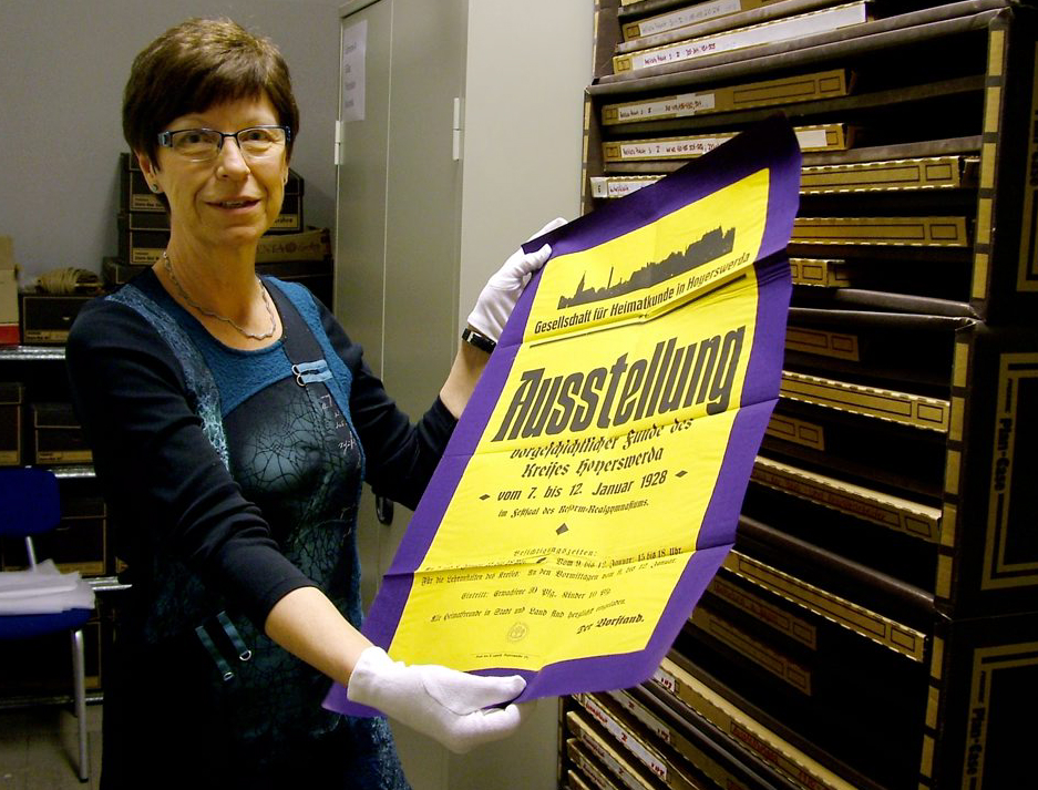 Die wissenschaftliche Leiterin des Museums, Elke Roschmann, mit einem Plakat von 1928. Foto: Uwe Jordan