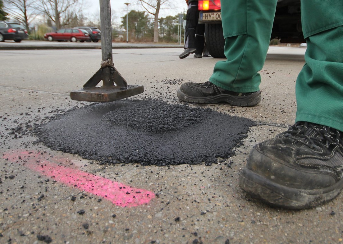 Asphalt-Kleckse füllen Löcher