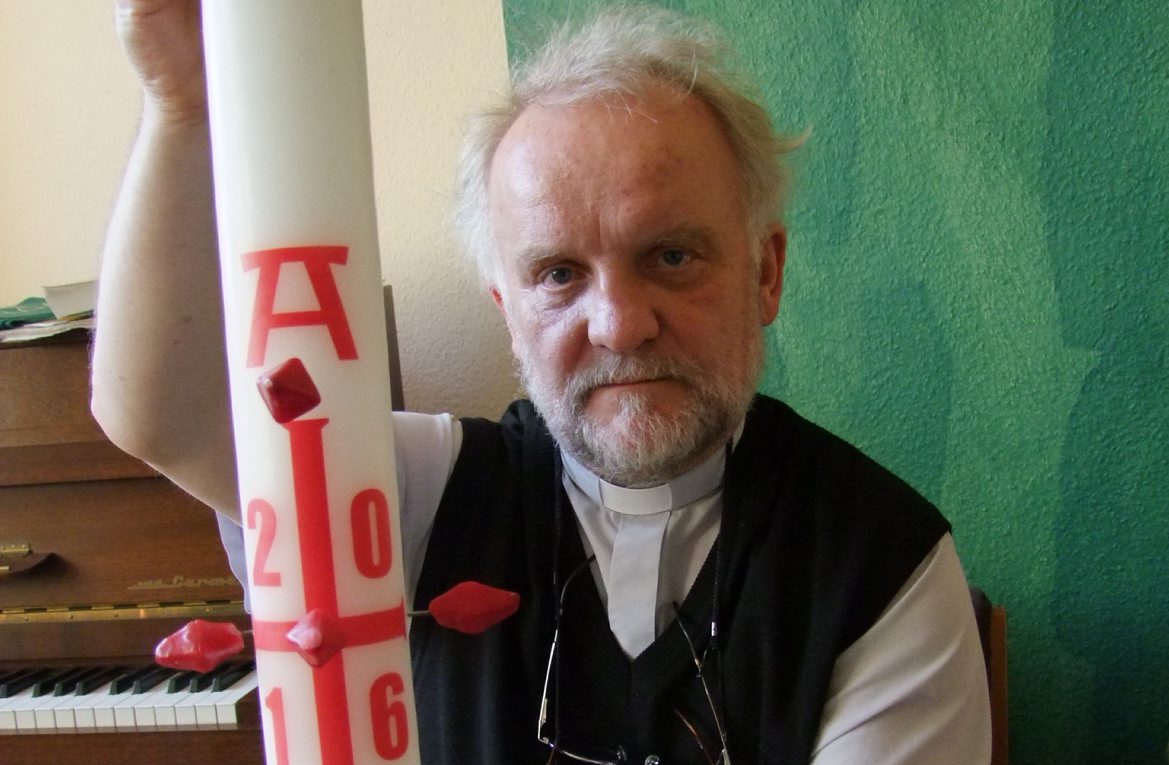 Pfarrer spendet Kerzen