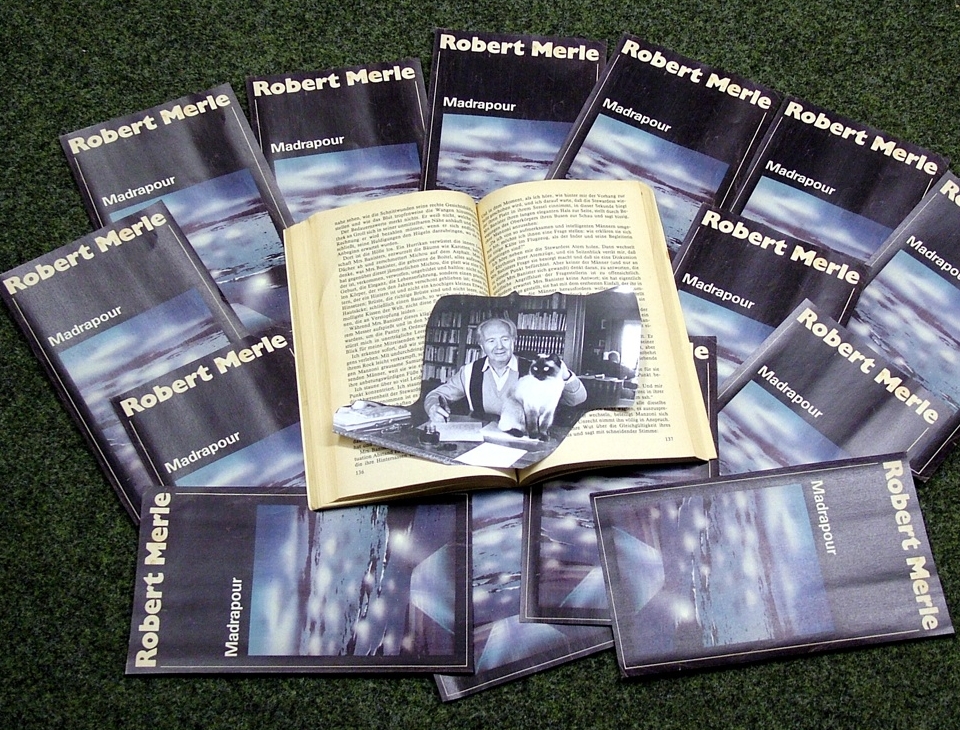 Robert Merle anno 1985 mit Katze inmitten der Titelseiten seines Romans "Madrapour". Foto: Uwe Jordan