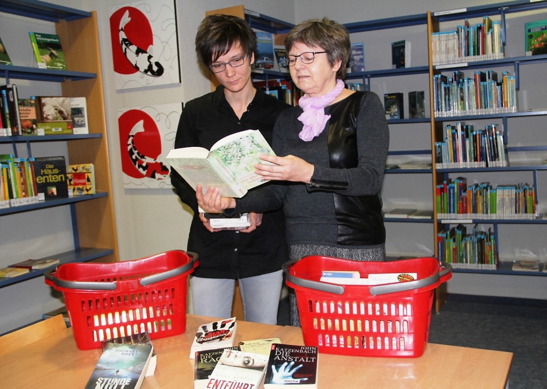 Maritta Knothe, rechts, und Annekathrin Trojan beim Packen von Bücherkörben für den sozialen Bücherhausdienst.  Foto: Heinz Hirschfeld