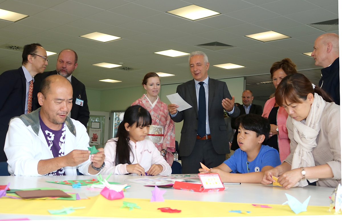 Ministerpräsident Stanislaw Tillich war beim Tag der Unternehmen in Bernsdorf dabei. Hier schaut er in der Firma TDDK in Straßgräbchen einer japanischen Familie beim Origami zu. Foto: Fürst