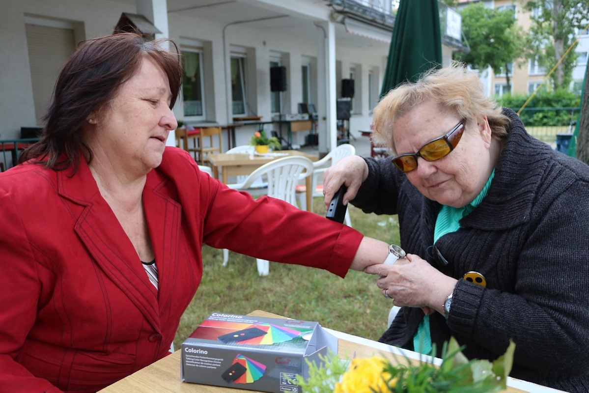 Im windigen Garten am Haus der Parität muss Waltraut Flade genau hinhören, was das neue Farberkennungsgerät zur Jacke von Haussprecherin Christine Pavelka sagt. Foto: Fürst