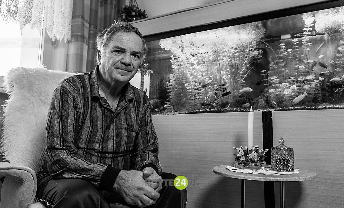Man sieht Harald Wukasch vor einem Aquarium.