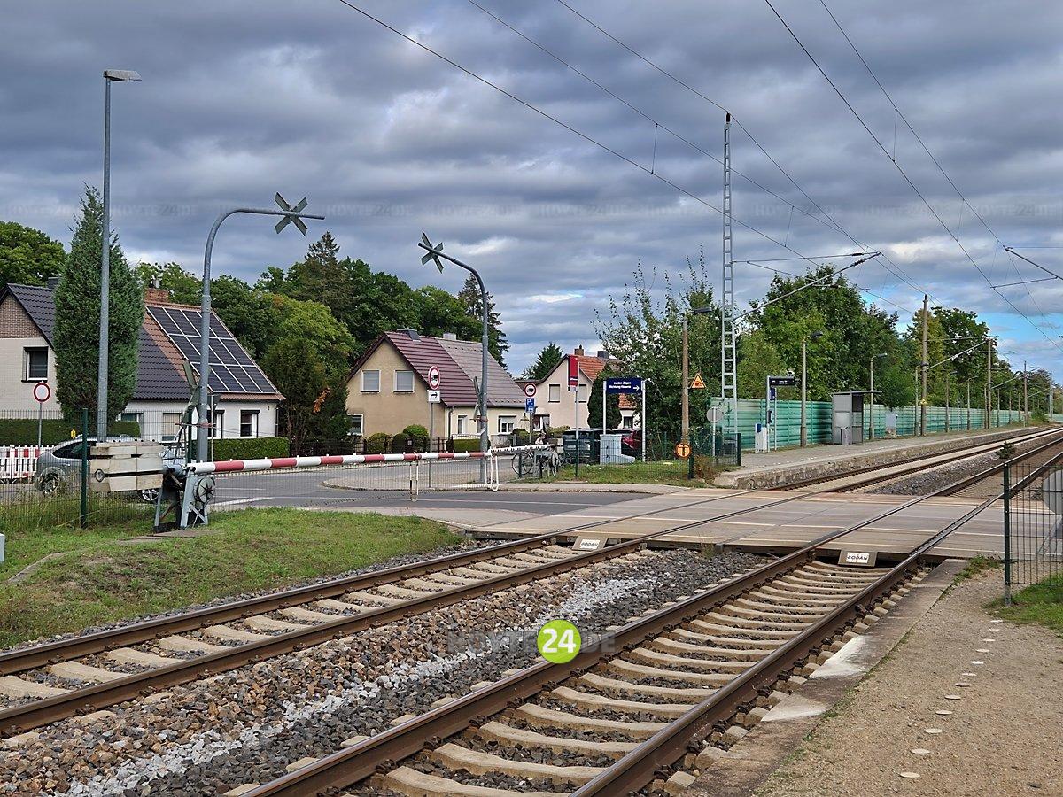 Man sieht die geschlossene Bahnschranke an der Karl-Liebknecht-Straße in Lauta sowie das Gleis.