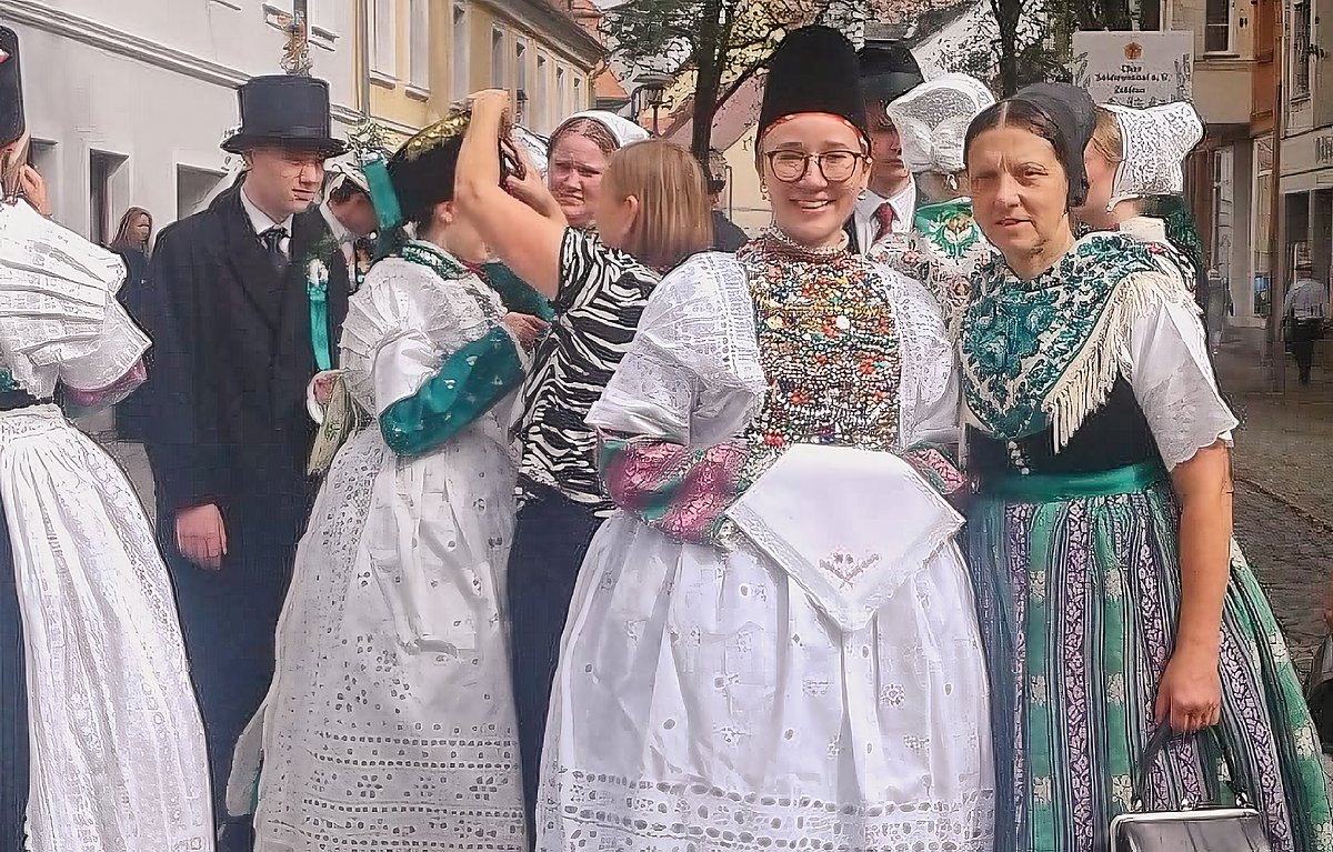 Man sieht Birgit Hantschick und andere Menschen in sorbischer Tracht vor dem Umzug zum Landeserntedankfest am 14. September in der Friedrichsstraße stehend.