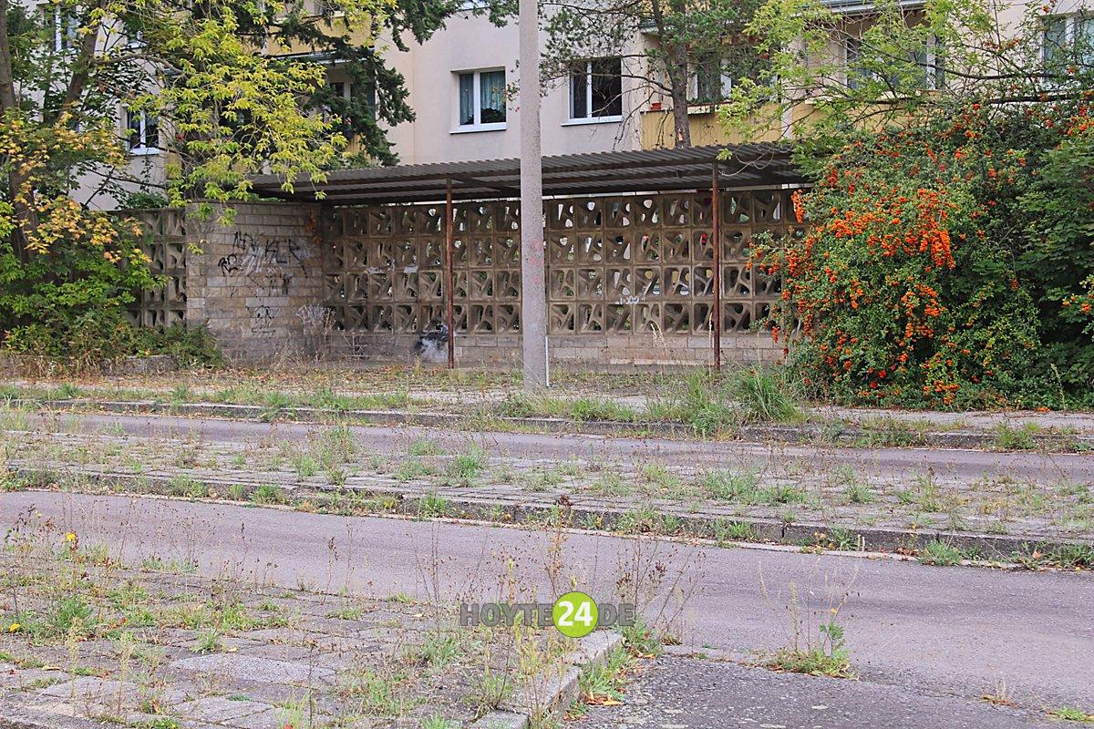 Man sieht den früheren Busbahnhof hinterm Hochhaus am Knie in Hoyerswerda.