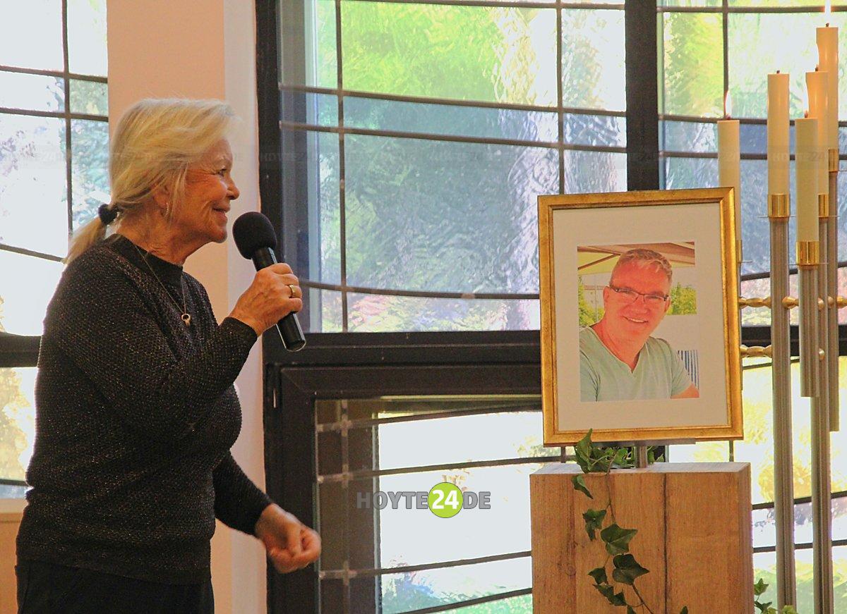 Man sieht Dorit Gäbler mit einem Mikrofon und einem Bild von Ralf Gerstmann.