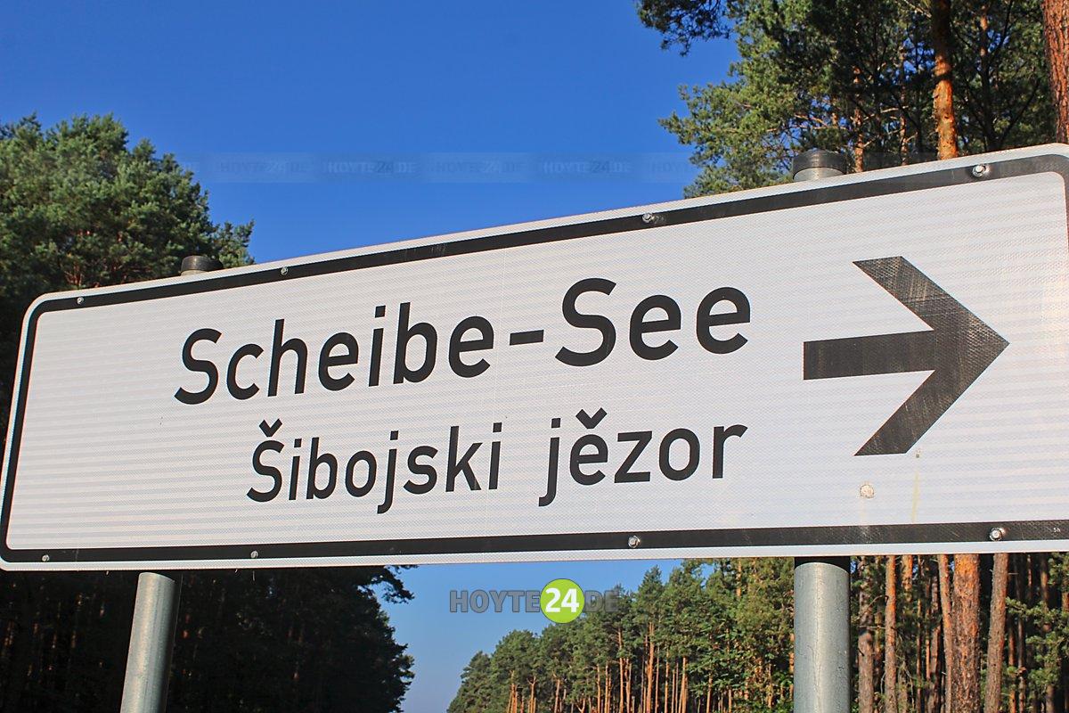 Man sieht ein Schild mit der Aufschrift Scheibe-See, Sibojski jezor.