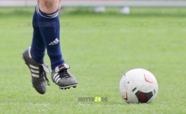 Man sieht einen Fußball und zwei Fußballerbeine.