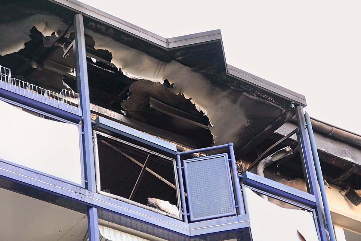 Man sieht den abgebrannten Balkon von unten.