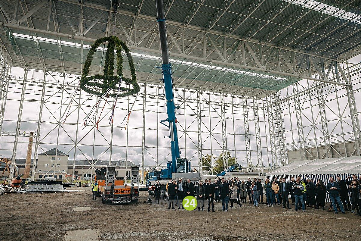 Man sieht Leute unterm Richtkranz.