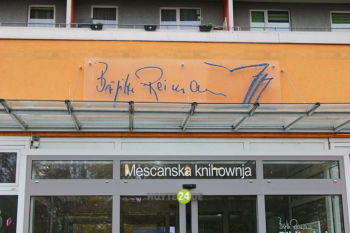 Man sieht den Schriftzug Brigitte Reimann Stadtbibliothek Mescanska knihownja an der Fassade der Bonhoefferstraße.