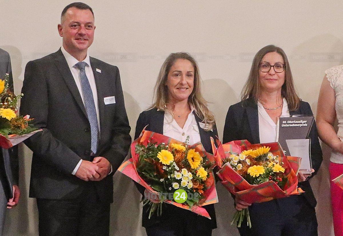 Man sieht Landrat Udo Witschas sowie Zita Galai und Julika Franz der Firma Zmalerei.