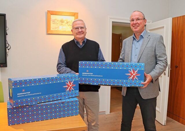 Man sieht Torsten Ruban-Zeh und Steffen Markgraf mit drei Kisten mit Herrnhuter Sternen.