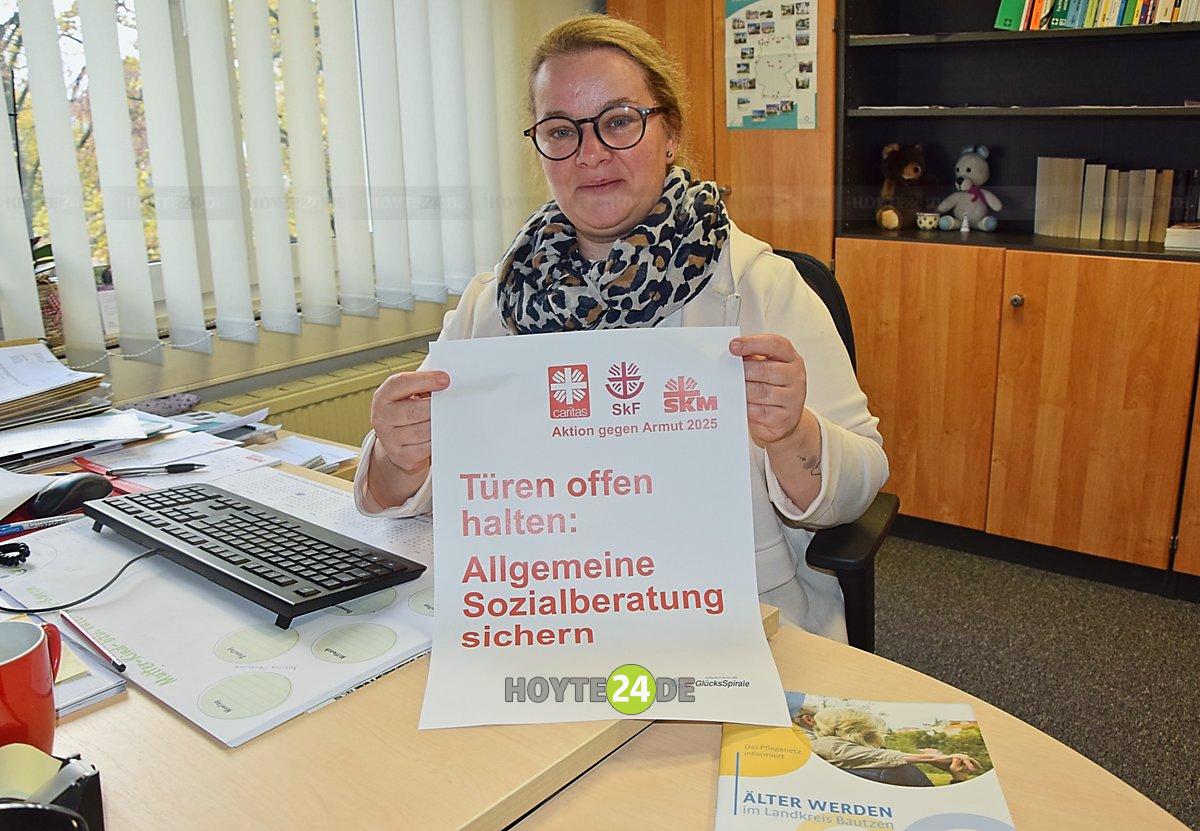 Man sieht Anja Münster mit dem Plakat der Armutswochen.