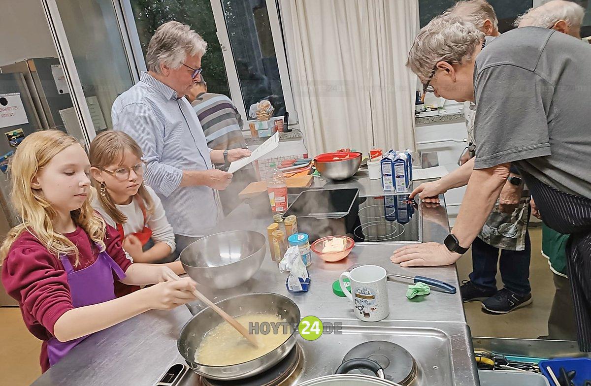 Man sieht Kinder und Senioren beim gemeinsamen Kochen.