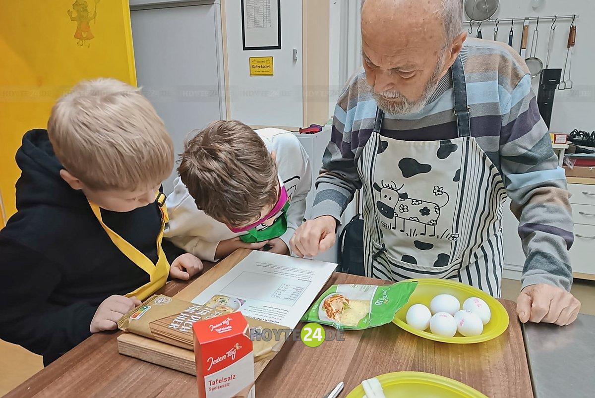 Man sieht Kinder und Senioren beim gemeinsamen Kochen.