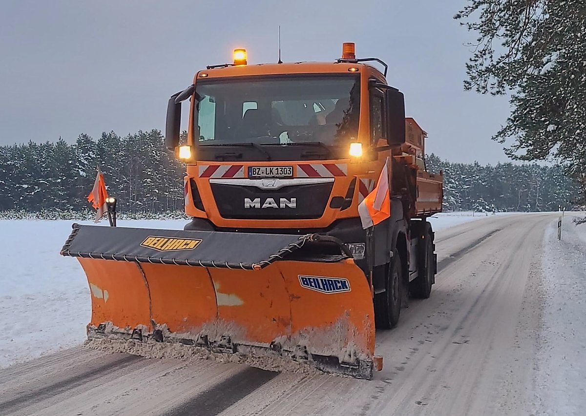 Man sieht ein Räum- und Streufahrzeug im Winterdienst beim Schneeschieben.