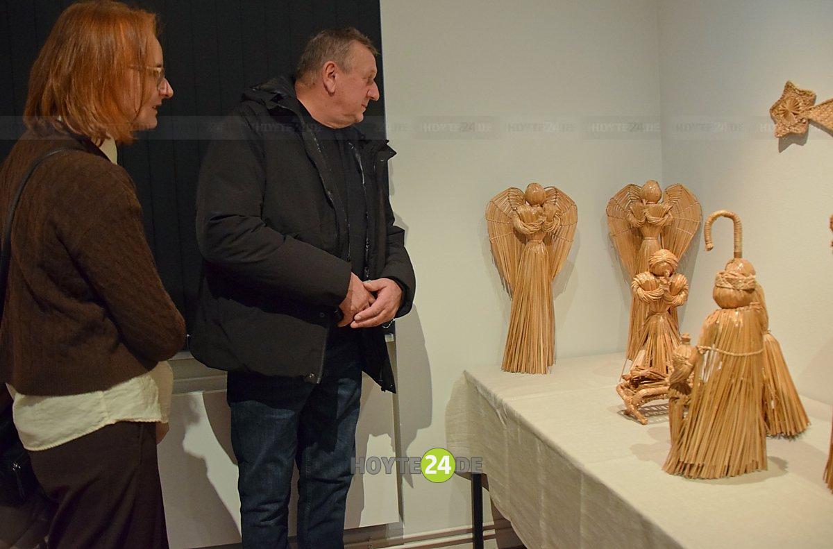 Man sieht Besucher in Betrachtung von Krippen.