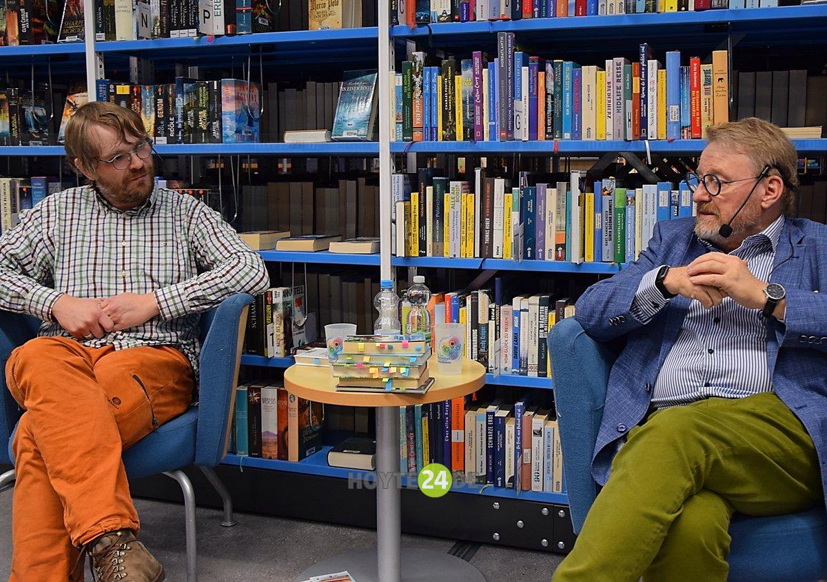 Man sieht Christian Völker-Kieschnick und Frank Dietrich in der Bibliothek.