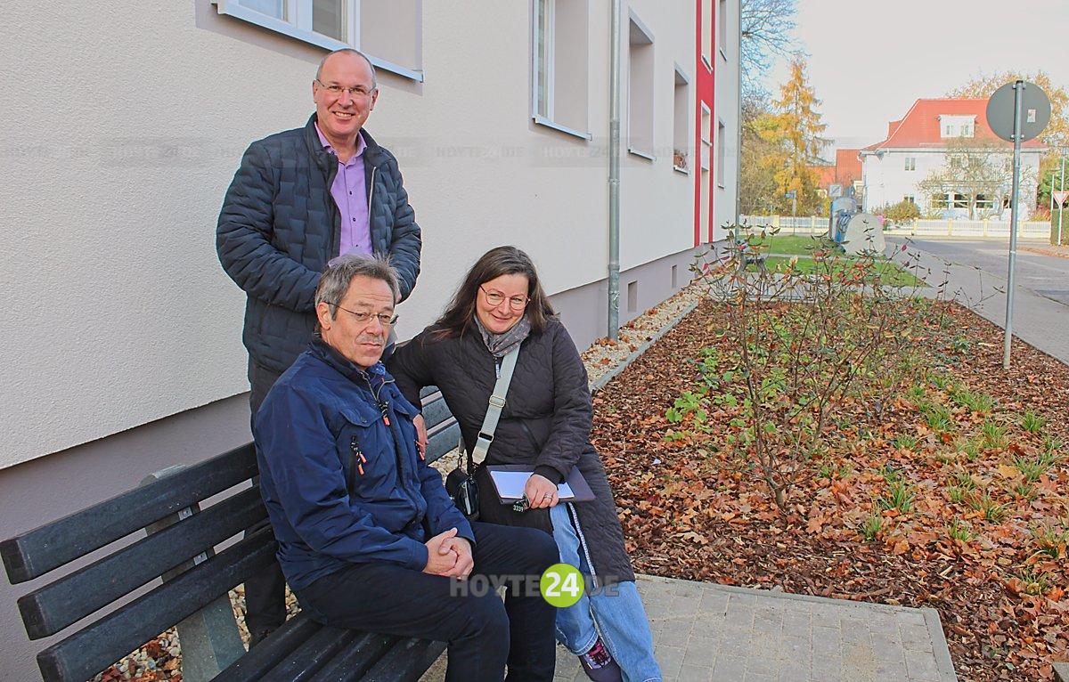 Man sieht WH-Chef Steffen Markgraf, Gebäudeplaner Jens Müller und Grünplanerein Ulrike Kühne auf einer Bank vorm Haus.