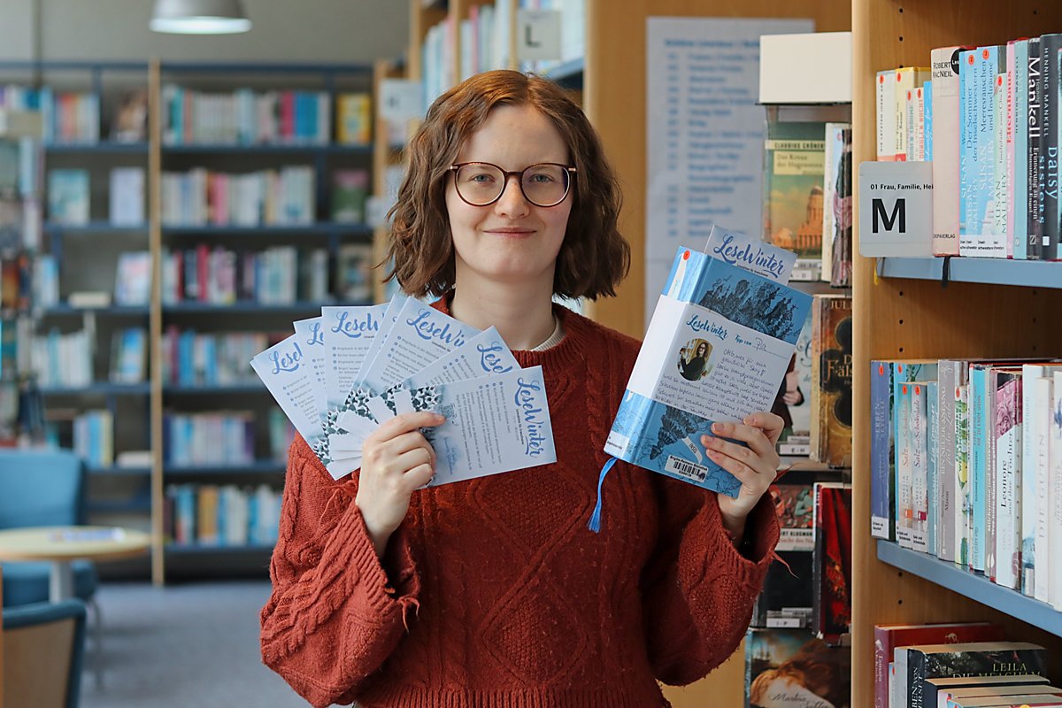 Man sieht Pia Gutsche mit Werbematerial für den Lesewinter.