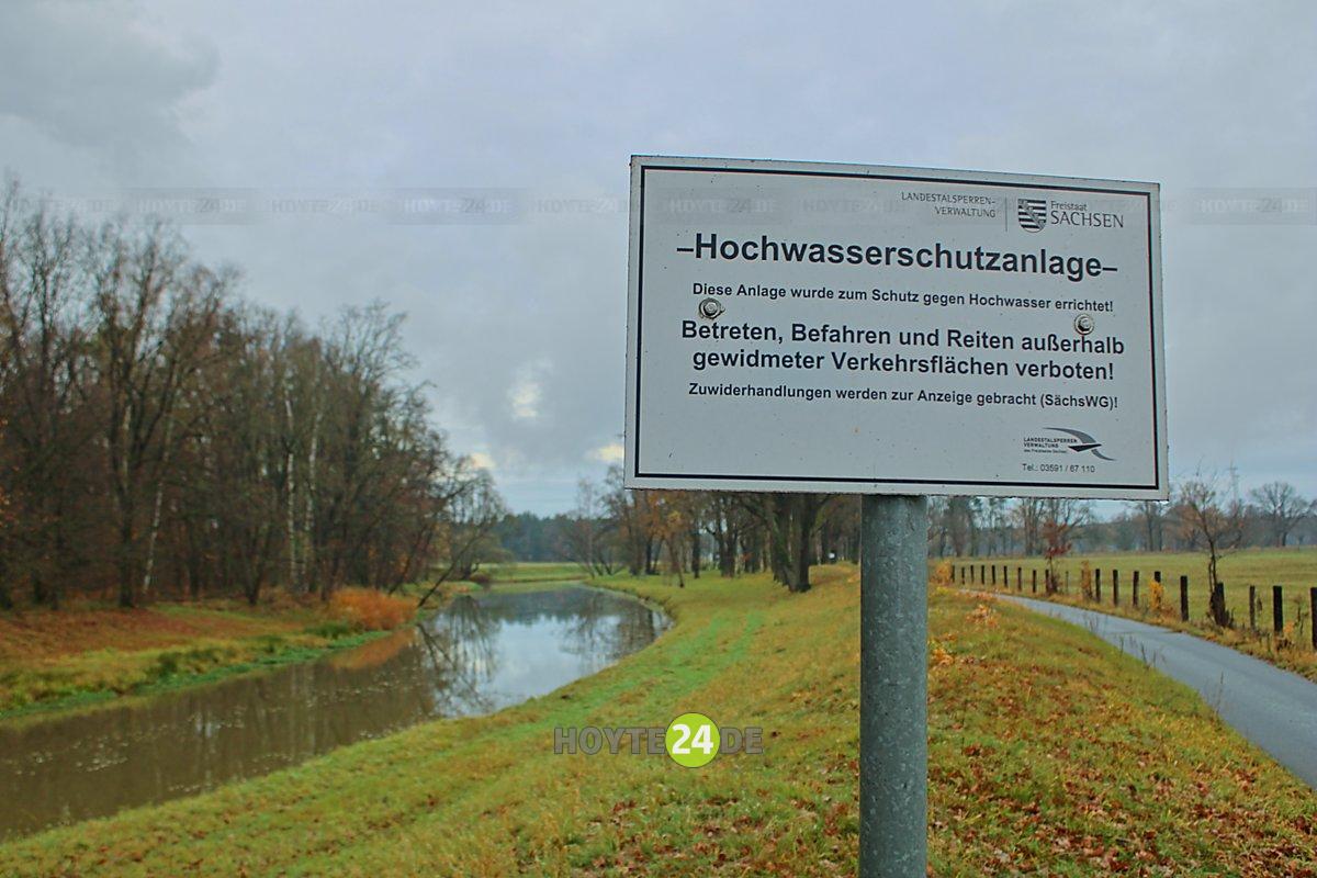 Man sieht die Spreeaue bei Spreewitz mit dem Schild Hochwasserschutzanlage.