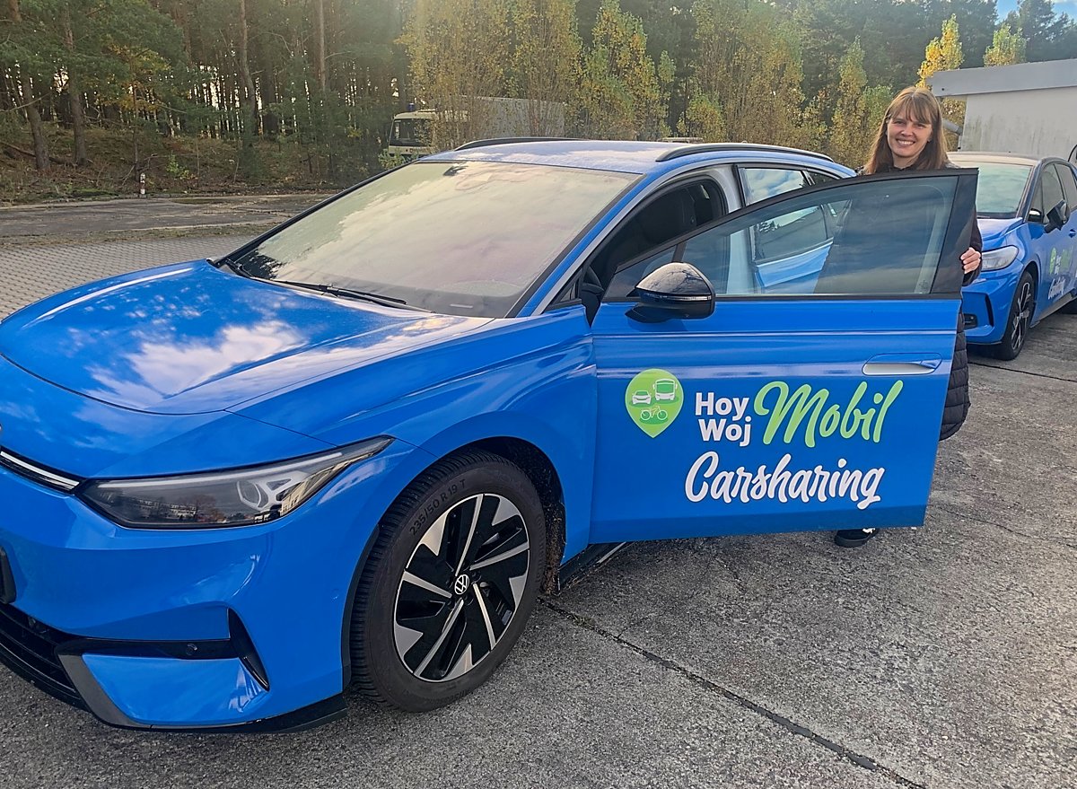 Man sieht Sandra Trebesius mit zwei der Autos.