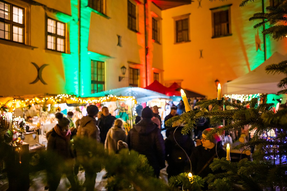 Man sieht Weihnachtsmarkt-Getümmel im Schlosshof.