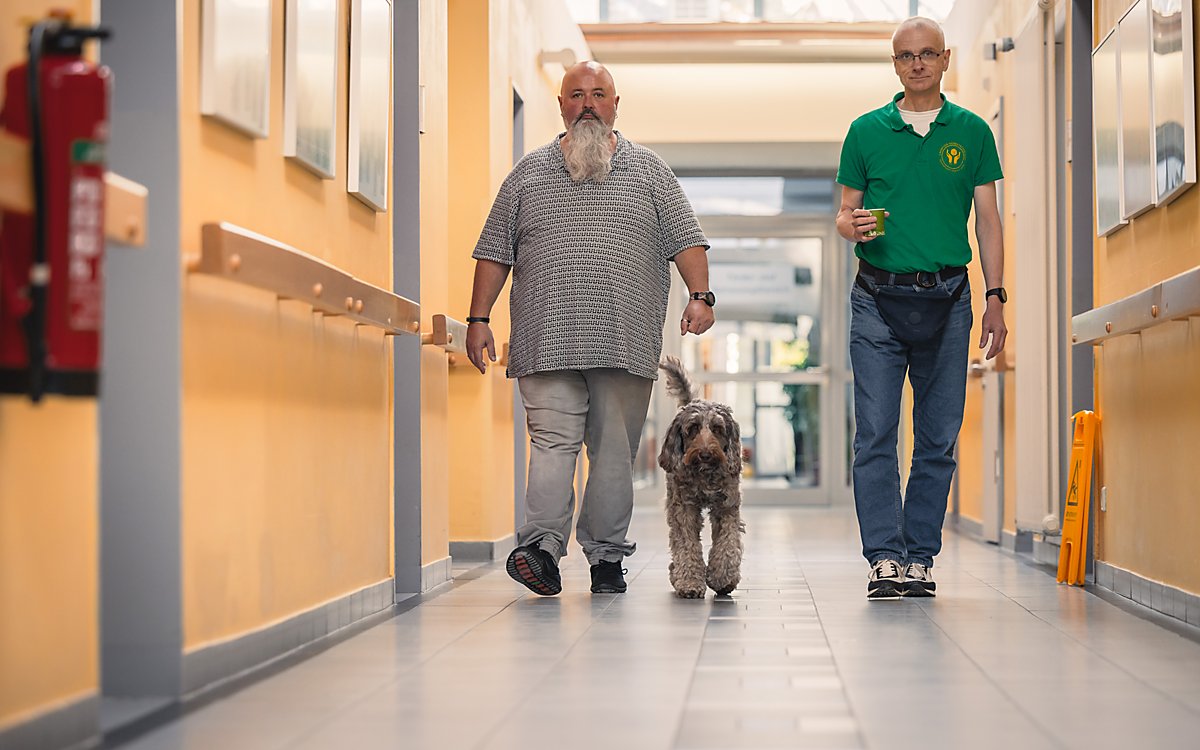 Man sieht Bente mit Begleitung im Werkstatt-Flur.