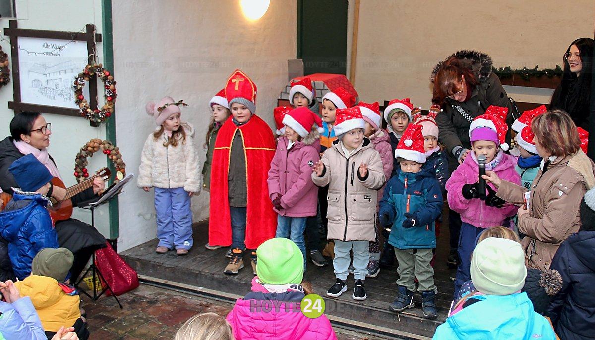 Man sieht den Auftritt der Kinder des Lutki-Hauses im weihnachtlich geschmückten Zeißighof.