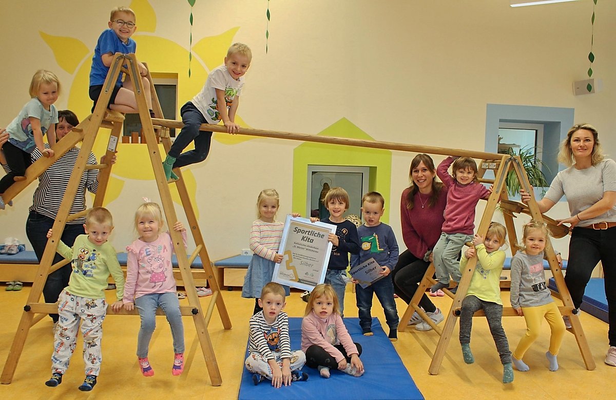 Man sieht Kinder im Sportraum der Kita St. Marien in Wittichenau mit der Urkunde Sportliche Kita.