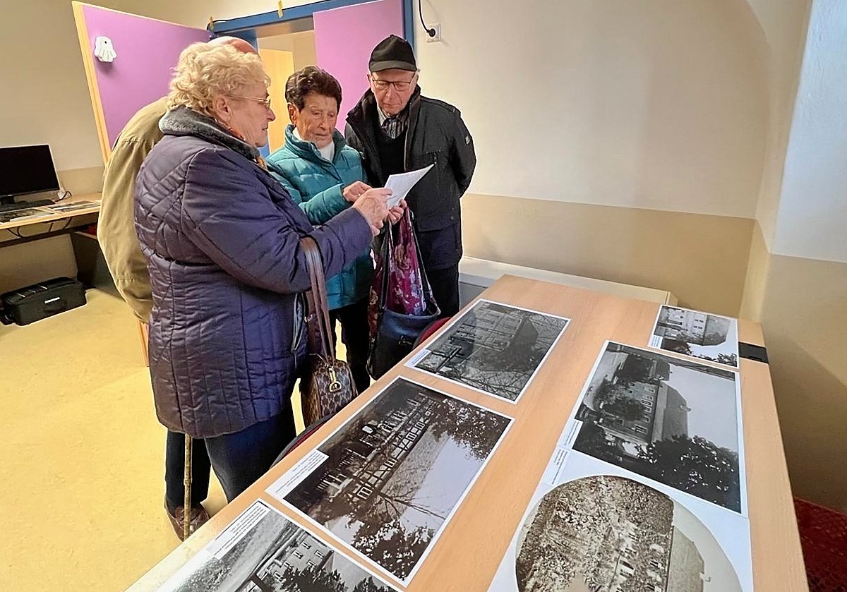 Man sieht Besucher beim Betrachten von Bildern in der Ausstellung.