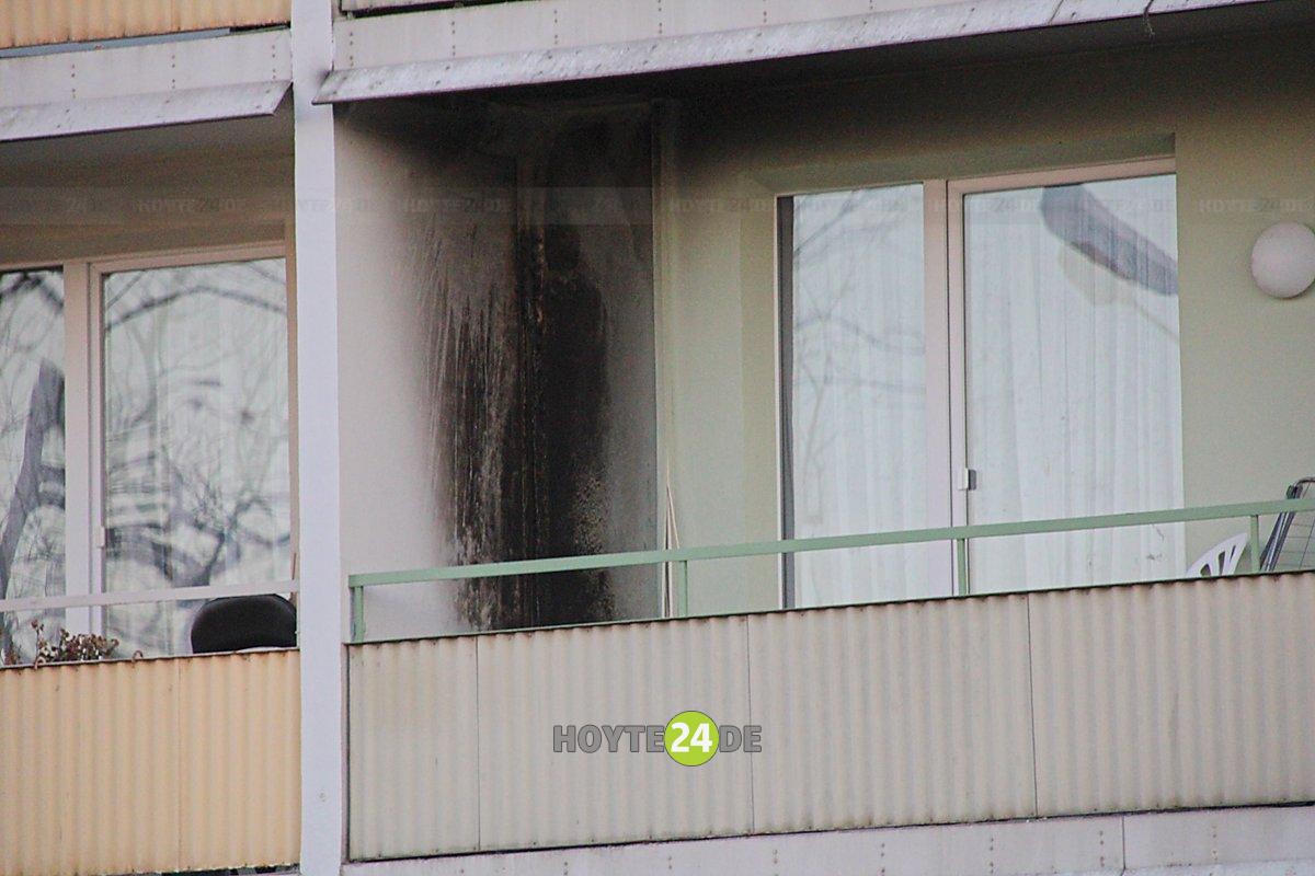 Man sieht den Balkon mit angerußter Fassade.