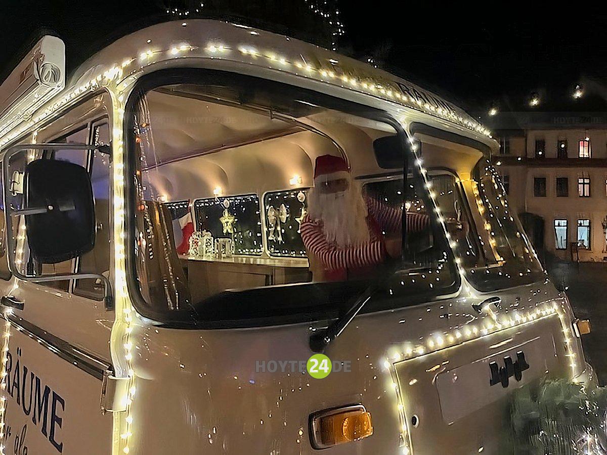 Man sieht den Weihnachtsmann im Weihnachtsbus.