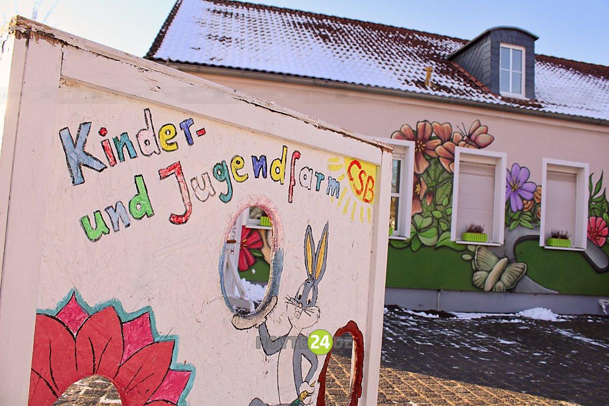 Man sieht das Gebäude der Kinder- und Jugendfarm mit einem entsprechenden Schild davor.