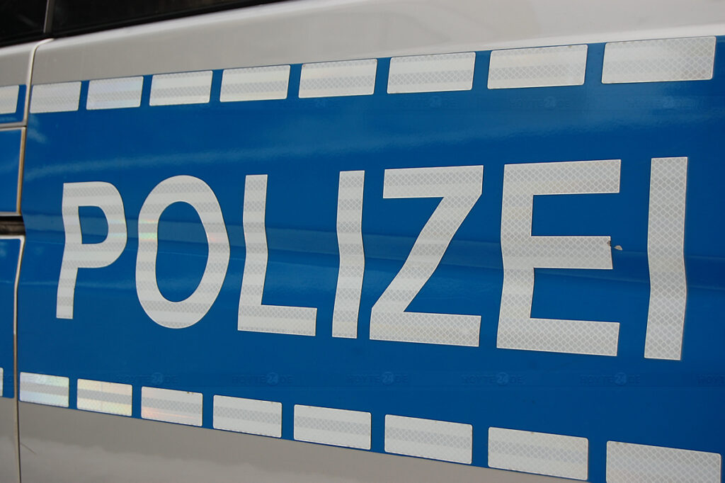 Man sieht den Schriftzug eines Polizeiwagens.