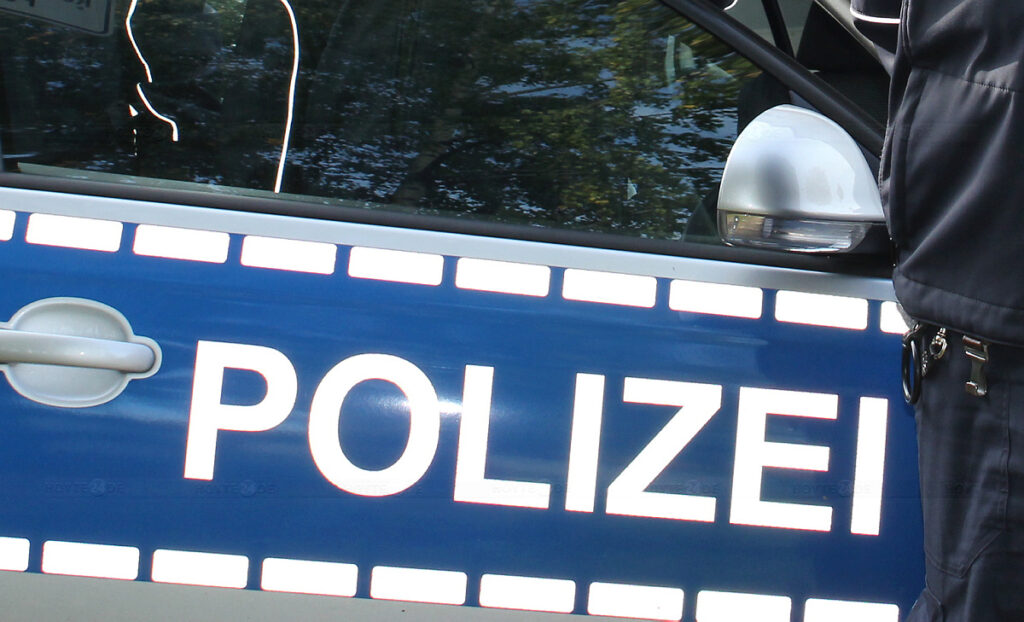 Man sieht den Schriftzug eines Polizeiwagens.