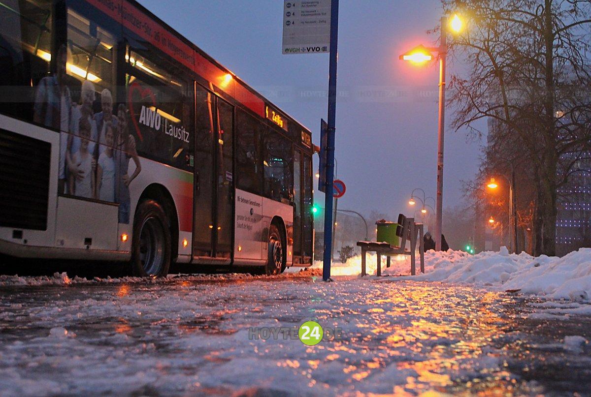 Man sieht eine eisglatte Haltestelle und einen Bus der VGH nach Zeißig.