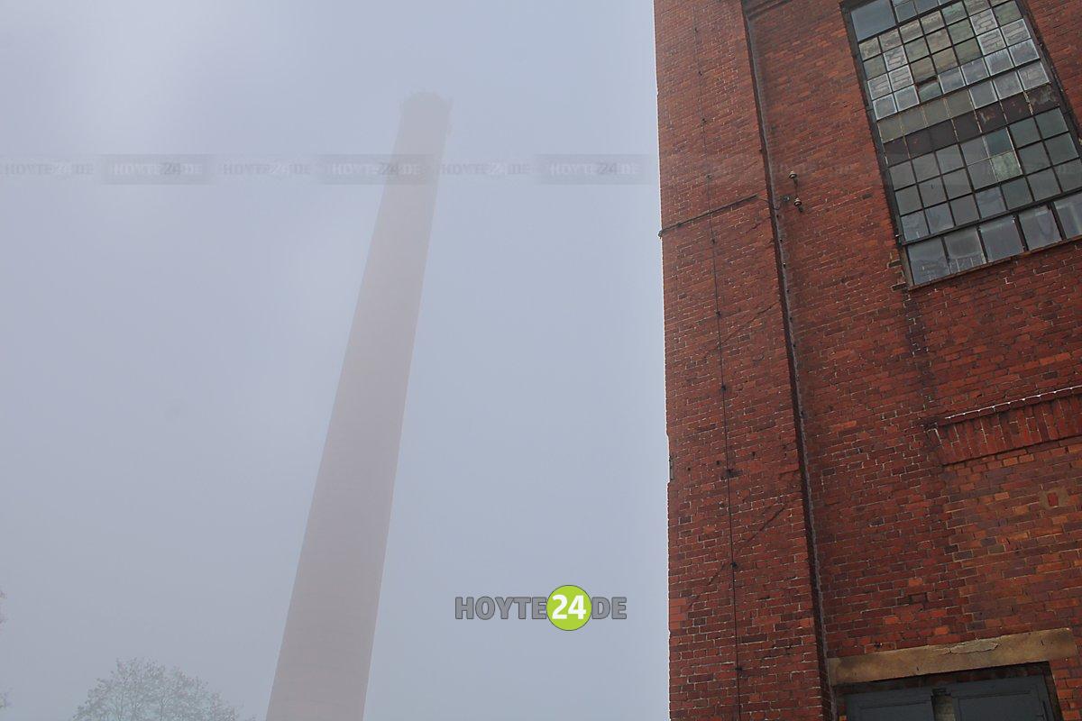 Man sieht den Schornstein der Energiefabrik Knappenrode im Nebel.