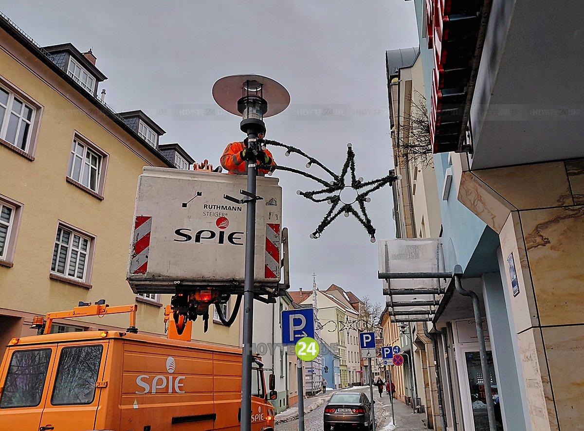 Man sieht, wie in der Kirchstraße Adventsschmuck abgenommen wird.
