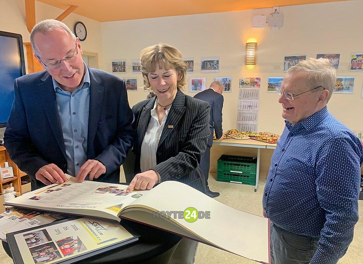Man sieht Steffen Markgraf, Daniela Fünfstück und Steffen Markgraf beim Blättern in der Chronik.