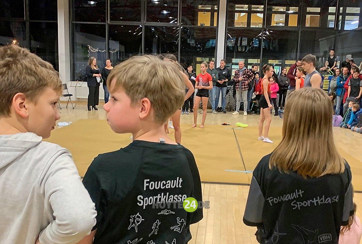 Man sieht Kinder mit T-Shirts "Foucault Sportklasse".
